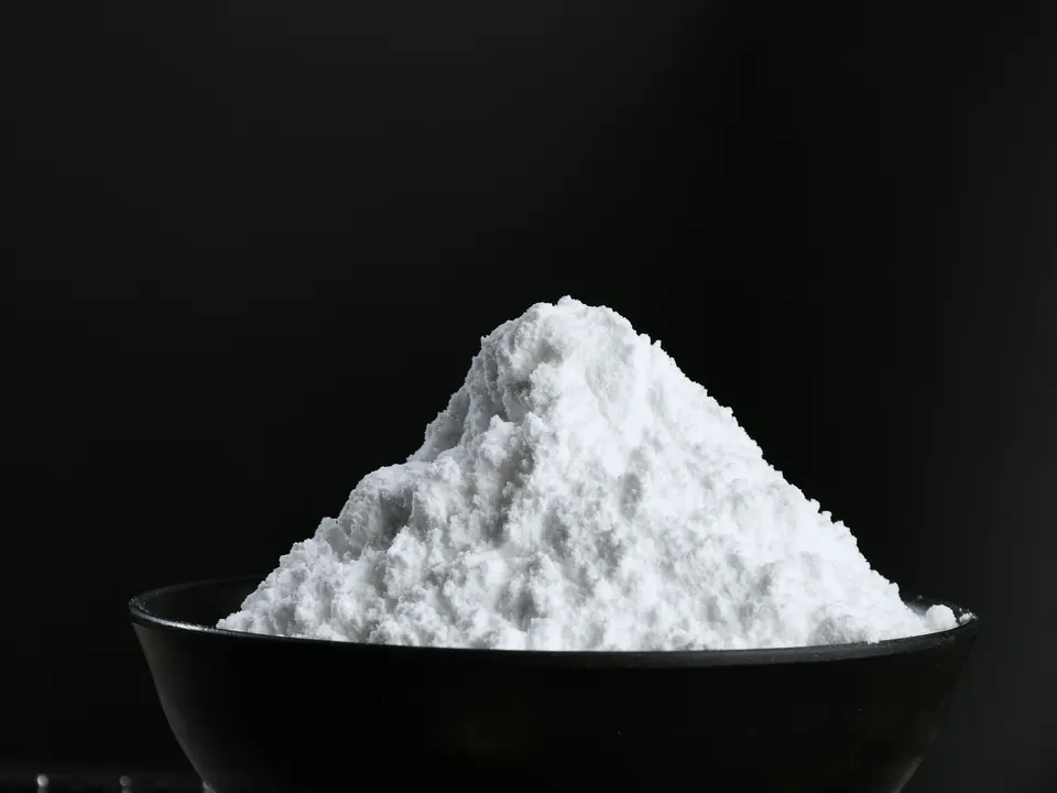 Fine white powder heaped in a black bowl